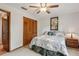 Comfortable bedroom features a ceiling fan, light colored carpet, and a closet with louvered doors at 5633 99Th N Ter, Pinellas Park, FL 33782