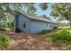 Exterior side view of the house showing the light blue siding and foliage near the house at 5633 99Th N Ter, Pinellas Park, FL 33782
