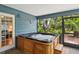 Enclosed patio showcasing a hot tub with steps and a view through the screened wall to the outside at 5633 99Th N Ter, Pinellas Park, FL 33782
