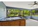 Enclosed patio featuring a hot tub with a scenic view through a screened wall to the lush, green yard at 5633 99Th N Ter, Pinellas Park, FL 33782
