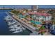 Aerial view of a luxurious waterfront clubhouse with pools, manicured grounds, and boat docks filled with yachts at 5701 Bowen Daniel Dr. # 806, Tampa, FL 33616