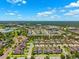 Community aerial view with tree-lined streets, well-maintained landscaping and a distant wooded skyline at 5831 Caldera Ridge Dr, Lithia, FL 33547