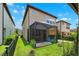 Exterior view of a home with a screened patio, lush lawn, and blue patio furniture at 5831 Caldera Ridge Dr, Lithia, FL 33547