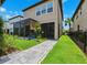Backyard featuring a screened patio, landscaped lawn, and walkway to the home at 5831 Caldera Ridge Dr, Lithia, FL 33547