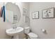 Bright half-bathroom with pedestal sink, wall art and modern fixtures at 5831 Caldera Ridge Dr, Lithia, FL 33547