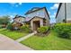 Charming two-story home showcasing a covered porch, manicured lawn, and vibrant landscaping at 5831 Caldera Ridge Dr, Lithia, FL 33547