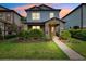 Charming two-story home showcasing a covered porch, manicured lawn, and vibrant landscaping at 5831 Caldera Ridge Dr, Lithia, FL 33547