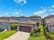 View of detached garage with brown door, lawn, and partial view of neighboring houses at 5831 Caldera Ridge Dr, Lithia, FL 33547