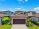 View of detached garage with brown door, lawn, and partial view of neighboring houses at 5831 Caldera Ridge Dr, Lithia, FL 33547