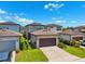 View of detached garage with brown door, lawn, and partial view of neighboring houses at 5831 Caldera Ridge Dr, Lithia, FL 33547