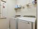 Laundry area featuring modern washer and dryer with storage shelving at 5831 Caldera Ridge Dr, Lithia, FL 33547