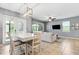 Open-concept living room features a dining table, tile flooring, and a comfortable sofa with natural light at 5831 Caldera Ridge Dr, Lithia, FL 33547