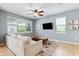 Comfortable living room with a TV, modern ceiling fan, and natural light from multiple windows at 5831 Caldera Ridge Dr, Lithia, FL 33547
