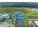 Community aerial view showcases the pool, tennis courts, bocce ball, playground, and surrounding green spaces at 6133 Wire Grass Ct, Nokomis, FL 34275
