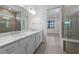 Bright bathroom featuring a double sink vanity, glass shower, and tile accents at 6133 Wire Grass Ct, Nokomis, FL 34275