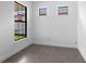 An empty bedroom featuring neutral tile floors and windows with natural light at 6133 Wire Grass Ct, Nokomis, FL 34275