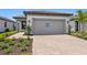 Charming single-story home boasts a paved driveway, landscaped yard and neutral-colored stucco exterior at 6133 Wire Grass Ct, Nokomis, FL 34275
