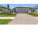 Charming single-story home boasts a paved driveway, landscaped yard and neutral-colored stucco exterior at 6133 Wire Grass Ct, Nokomis, FL 34275