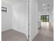 Hallway view with neutral tile floors and a view of a modern kitchen and backyard at 6133 Wire Grass Ct, Nokomis, FL 34275