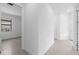 Bright hallway with neutral tile floors and white walls, leading to a bedroom at 6133 Wire Grass Ct, Nokomis, FL 34275