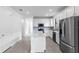 Modern kitchen featuring stainless steel appliances, white cabinetry, and a center island with quartz countertops at 6133 Wire Grass Ct, Nokomis, FL 34275