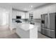Spacious kitchen featuring stainless steel appliances, white cabinetry, and a center island with quartz countertops at 6133 Wire Grass Ct, Nokomis, FL 34275