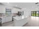 Bright open kitchen featuring a center island with quartz countertops and stainless steel appliances at 6133 Wire Grass Ct, Nokomis, FL 34275