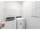 Functional laundry room with washer, dryer, and overhead storage at 6133 Wire Grass Ct, Nokomis, FL 34275