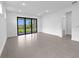 Spacious living area featuring recessed lighting, tile floors, and a sliding glass door at 6133 Wire Grass Ct, Nokomis, FL 34275