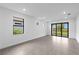 Bright and airy living room featuring large windows, glass doors, and tile floors at 6133 Wire Grass Ct, Nokomis, FL 34275