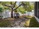 Spacious backyard featuring a playhouse, saucer swing, mature trees, and a white privacy fence at 615 6Th N Ave, Safety Harbor, FL 34695
