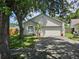 Inviting single-story home with a spacious two-car garage and landscaped front yard, shaded by mature trees at 6203 Calamari Pl, Riverview, FL 33578