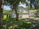 Single story home featuring a 2 car garage, complemented by mature landscaping and tree-shaded lawn at 6203 Calamari Pl, Riverview, FL 33578