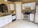 A kitchen featuring white cabinets, stainless steel appliances, and tile flooring at 6203 Calamari Pl, Riverview, FL 33578