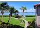 Scenic water view with palm trees, a tiki hut, and lush greenery at 6218 Palma Del Mar S Blvd # 503, St Petersburg, FL 33715