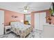 Bedroom with pink walls, ceiling fan, and view of the window with natural light at 6417 Willow Wood Ln, Tampa, FL 33634