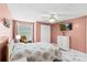 Bedroom with pink walls, ceiling fan, and view of the window with natural light at 6417 Willow Wood Ln, Tampa, FL 33634