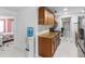 Bright kitchen featuring granite countertops, wooden cabinets, stainless steel refrigerator and white tile floors at 6417 Willow Wood Ln, Tampa, FL 33634