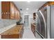 Bright kitchen featuring granite countertops, wooden cabinets, stainless steel refrigerator and tiled backsplash at 6417 Willow Wood Ln, Tampa, FL 33634