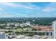 Expansive aerial view featuring lush greenery, buildings, and roadways under a bright blue, cloud-streaked sky at 777 N Ashley Dr # 2513, Tampa, FL 33602