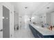Bright bathroom featuring double sinks, a marble countertop, and a glass shower with marble-patterned walls at 7892 10Th S Ave, St Petersburg, FL 33707