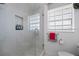 Bright bathroom with a tiled shower stall, glass door, and a built-in niche with stylish bath products at 7892 10Th S Ave, St Petersburg, FL 33707