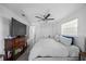 Modern bedroom with a large TV, sleek furnishings, and crisp white bedding, creating a cozy retreat at 7892 10Th S Ave, St Petersburg, FL 33707