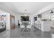 Open dining area with modern chandelier, tile floors and adjacent kitchen at 7892 10Th S Ave, St Petersburg, FL 33707