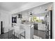 Modern kitchen features white cabinetry, stainless steel appliances, and a breakfast bar with seating at 7892 10Th S Ave, St Petersburg, FL 33707