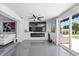 Bright living room features a modern fireplace, sleek gray tile, and sliding glass doors to the pool at 7892 10Th S Ave, St Petersburg, FL 33707