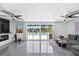 Open living room boasts sleek gray tile, modern ceiling fans, and sliding glass doors to the pool at 7892 10Th S Ave, St Petersburg, FL 33707