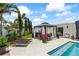 View of poolside featuring a gazebo, lounge chairs, and meticulously maintained landscaping at 7892 10Th S Ave, St Petersburg, FL 33707