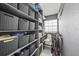 Well-organized walk-in closet with shelves, gray storage boxes, a window, and a cleaning station at 7892 10Th S Ave, St Petersburg, FL 33707