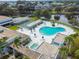 Aerial view showcasing a kidney-shaped community pool with lounge chairs and a tennis court at 8080 112Th St # 108, Seminole, FL 33772